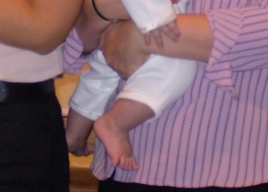 This is me holding Boo on the altar, with our family all around taking a group photo after the ceremony. I cropped it to zero in on Boo's feet.  There are no shoes on his feet.  No booties on his feet.  No nothin' on his feet, in church.  And he's wearing white pajamas.  Pa-JAMMM-ahhhs.